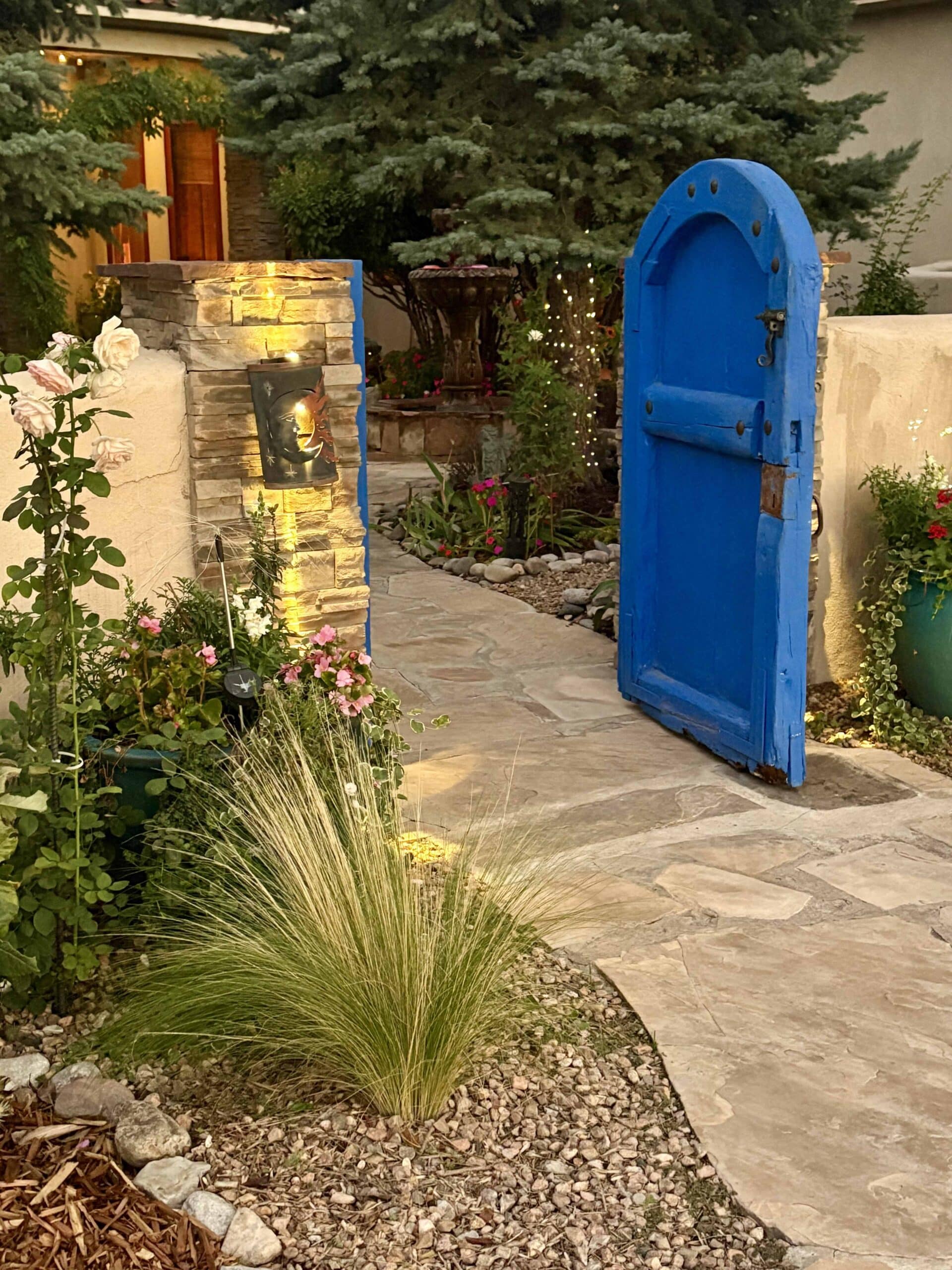 A blue door to a garden gate at Corrales Grief Spa